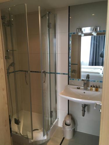 a bathroom with a glass shower and a sink at Landhotel Steffen in Lieser
