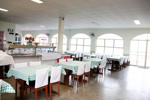 een eetkamer met groene en witte tafels en stoelen bij Hotel e Restaurante Champagne in Campo Belo