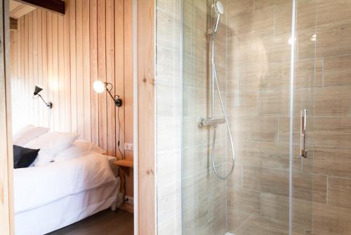 a bathroom with a shower and a bed in it at Centre Cap-ferret, les chambres du phare, bassin in Cap-Ferret