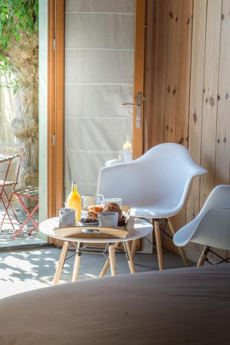 - une table avec un plateau de nourriture à côté de 2 chaises dans l'établissement Centre Cap-ferret, les chambres du phare, bassin, à Cap-Ferret