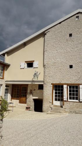 a large brick building with two windows and a garage at Chez Madgi et Jean-Mi in Froncles