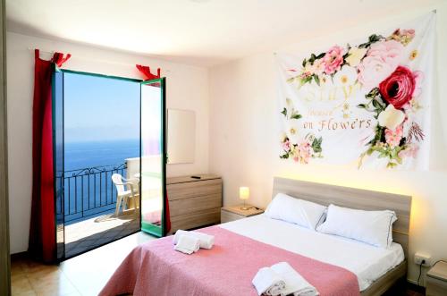 a bedroom with a large bed and a balcony at Amalfi Hills in Amalfi