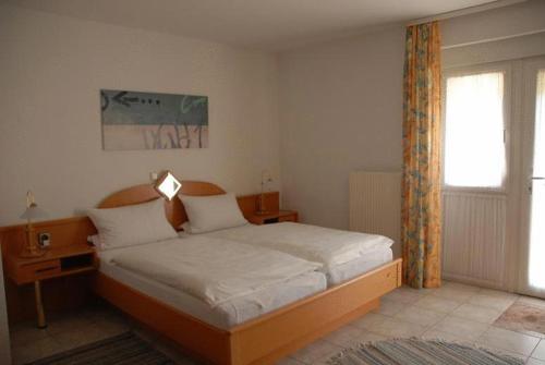 a bedroom with a bed in a room with a window at Hotel Restaurant Itzumer Paß in Hildesheim