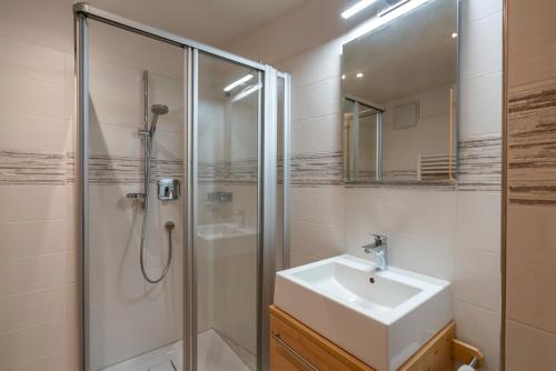 a white bathroom with a sink and a shower at Ragerhof in Versciaco di Sopra