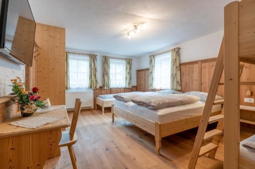 a bedroom with two bunk beds and a desk at Ragerhof in Versciaco di Sopra