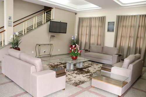 een woonkamer met 2 banken en een tv bij Hotel e Restaurante Champagne in Campo Belo