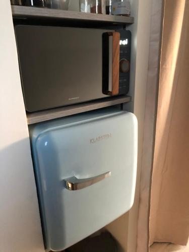 a refrigerator with a microwave on top of it at Escale beauté le Crotoy in Le Crotoy