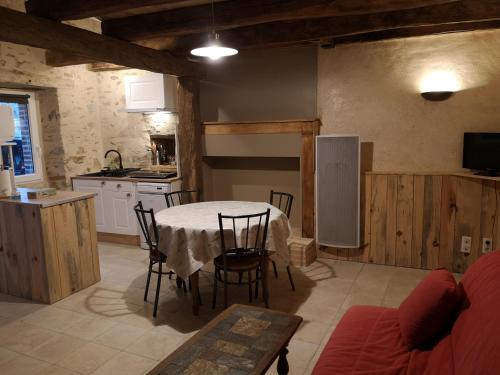 une cuisine et une salle à manger avec une table et des chaises dans l'établissement Gîte les genêts, à Saint-Fulgent