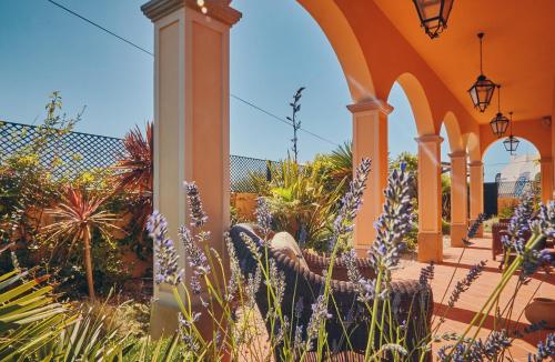 eine orangefarbene Terrasse mit lila Blumen und Pflanzen in der Unterkunft Silver Coast Beach Residence in Baleal