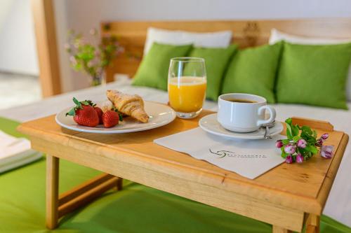 a breakfast table with a cup of orange juice and strawberries at Hotel Bachledówka in Zakopane