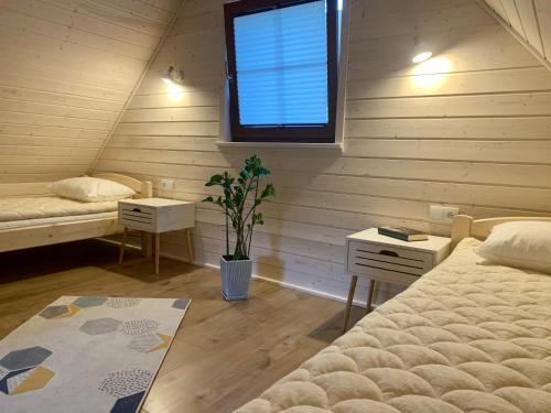 a room with two beds and a window in a attic at Zajazd Szałas Food&Rest in Żywiec
