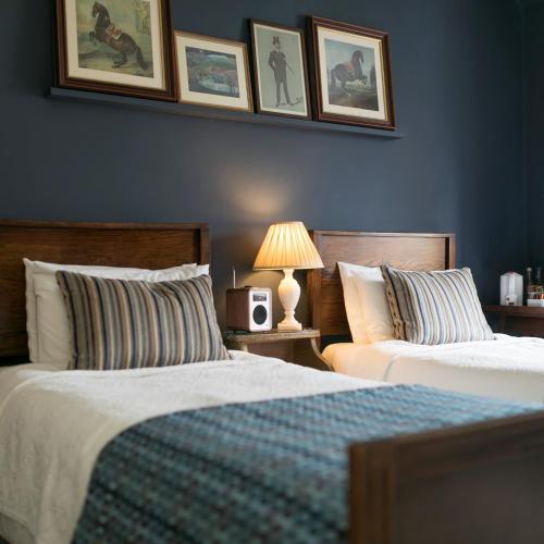 two beds in a bedroom with blue walls at Victoria House in Church Stretton