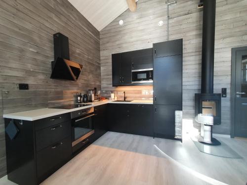a kitchen with black cabinets and black appliances at Seaview cabin Reine, Lofoten in Reine