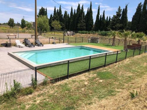 une piscine entourée d'une clôture dans l'établissement La Massoterie gîte 1, à Théza