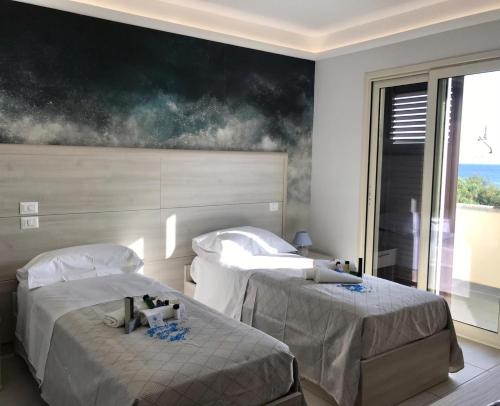 a bedroom with two beds and a painting on the wall at Il corallo azzurro in Reggio di Calabria