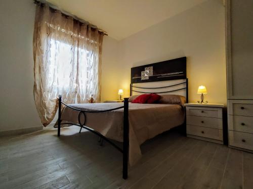 a bedroom with a bed and a dresser and a window at B&B Alghero Mare Chiaro in Alghero