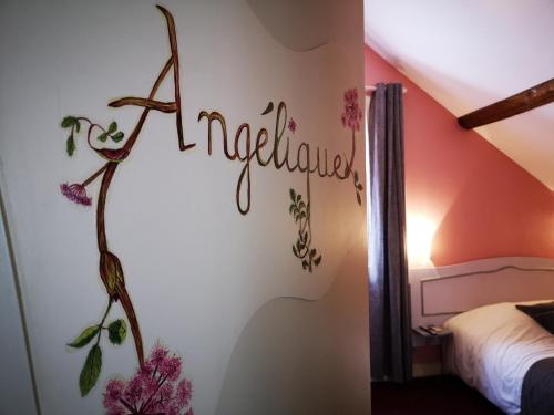 a bedroom with a sign that says miracles on the wall at "Maison D'hôtes du Prieuré" in Vignoux-sur-Barangeon