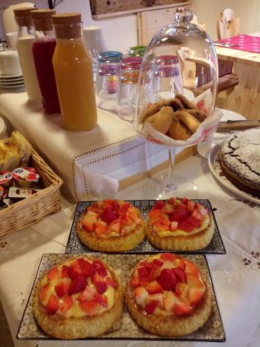 three pizzas with fruit on them on a table at B&B SognoInCadore in Domegge di Cadore