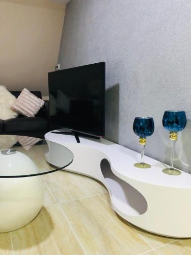 a living room with a tv and two wine glasses at Carla Maria S Hause in Gammertingen