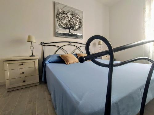 アルゲーロにあるB&B Alghero Mare Chiaroのベッドルーム1室(青いシーツと木のベッド1台付)