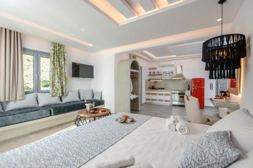 a living room with a large bed and a kitchen at Naxos Pantheon Luxury Apartments in Agkidia