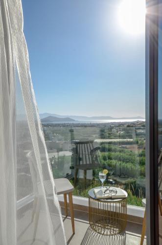 a balcony with a table and a glass of wine at Naxos Pantheon Luxury Apartments in Agkidia
