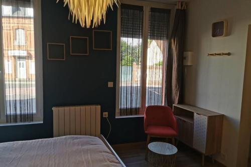 une chambre avec un lit et une chaise rouge dans l'établissement Le 112 st leo, à Honfleur