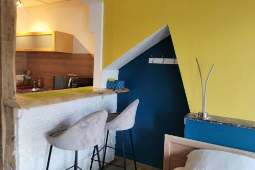 - une cuisine avec un comptoir et 2 chaises dans une pièce dans l'établissement Le 112 st leo, à Honfleur