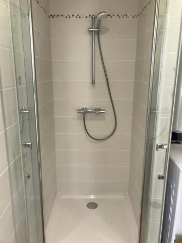 une douche dans une salle de bain avec une porte vitrée dans l'établissement Duplex calme et cosy, à Concarneau