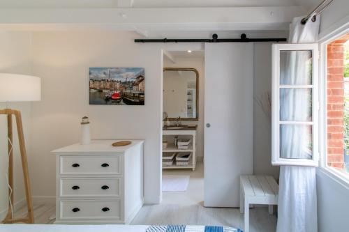 - une chambre avec une commode blanche et un miroir dans l'établissement La maison de Colette, Traditionnelle Maison d'Armateur de 3 chambres et 3 salles de bains, à Honfleur