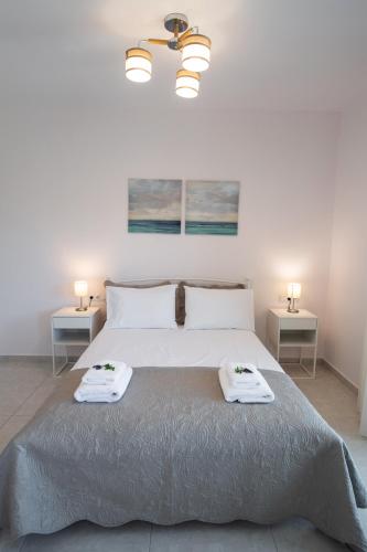 a bedroom with a large bed with two towels on it at Bounatsa Studios & Apartments in Nydri