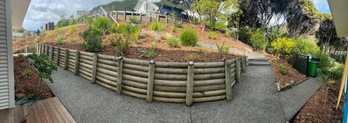 a garden with a fence and plants in it at Mokorau Apartments - The Mukies in Ahipara