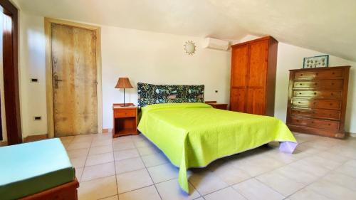 a bedroom with a green bed and a wooden dresser at Casa Santicelli Maratea “ Il Campanile” in Maratea