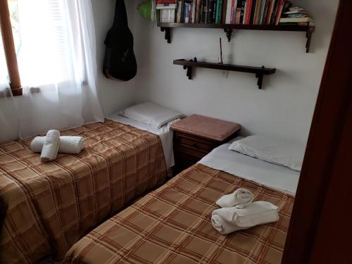 Vosso Lar com Vista Gramado في غرامادو: سريرين في غرفة عليها مناشف