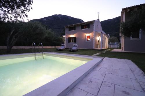 a swimming pool in the backyard of a house at Theonymfi Luxury Villas in Doukádes