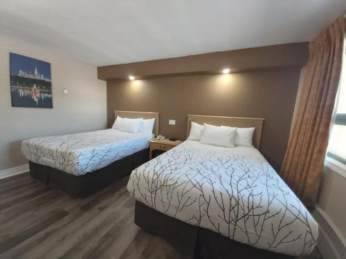a hotel room with two beds and a window at Arnprior Motor Inn in Arnprior