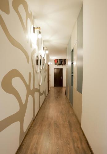 a hallway with a wall with trees painted on it at Different Apartments in Niš