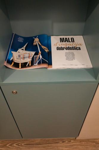 a shelf with two books and a box on it at Different Apartments in Niš
