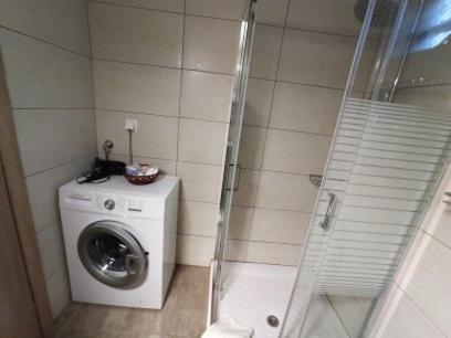 a bathroom with a washing machine and a shower at MGE Luxury house with pool in Iraklitsa