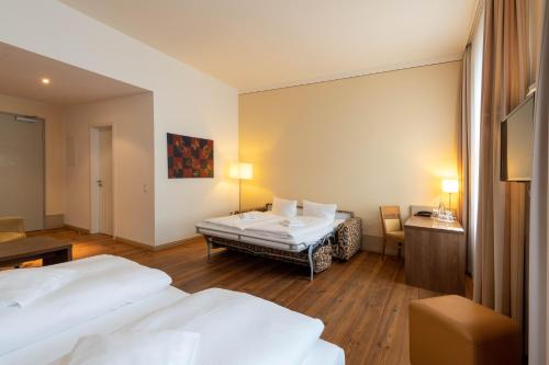 a hotel room with two beds and a desk at Hotel am Großen Waisenhaus in Potsdam
