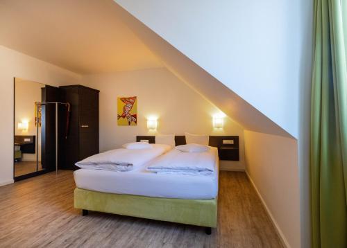 a bedroom with a bed with a sloped roof at Hotel am Großen Waisenhaus in Potsdam