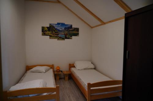 a room with two beds and a picture on the wall at Agroturystyka Witoldówka in Perlejewo
