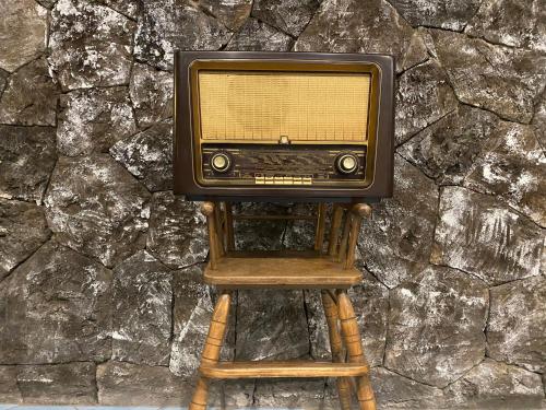 an old tv sitting on top of a wooden stool at Black Market Hotel in Ischia