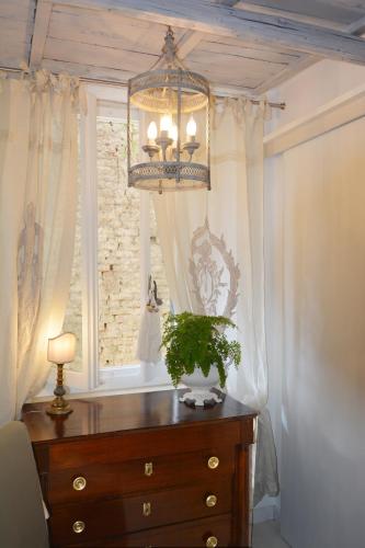 a chandelier hanging over a wooden dresser with a window at Le Stanze del Cardinale in Pavia