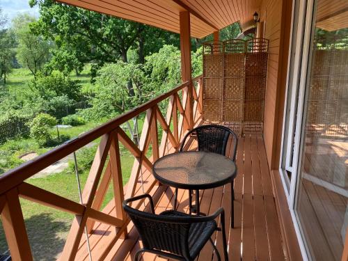 a porch with two chairs and a table on it at Green Gile Villa in Druskininkai Center in Druskininkai