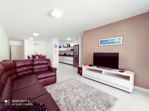 a living room with a couch and a flat screen tv at Marine Home Resort- piscina aquecida-hidromassagem in Florianópolis