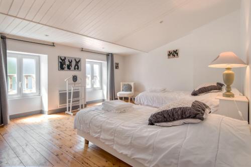1 dormitorio con 2 camas y mesa con lámpara en Appartement Sully en Saint-Martin-de-Ré