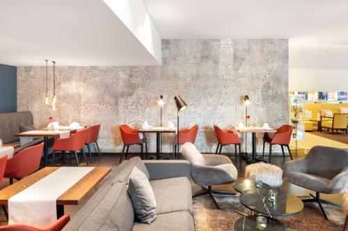 a restaurant with a couch and chairs and tables at Radisson Blu Hotel, St. Gallen in St. Gallen
