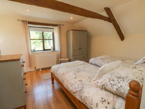 - une chambre avec 2 lits et une fenêtre dans l'établissement Owl's Nest, à South Molton