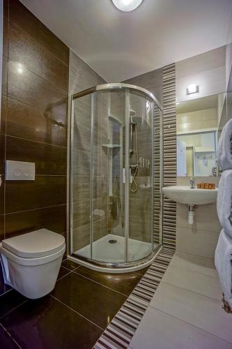 a bathroom with a shower and a toilet and a sink at Hotel Bachledówka in Zakopane
